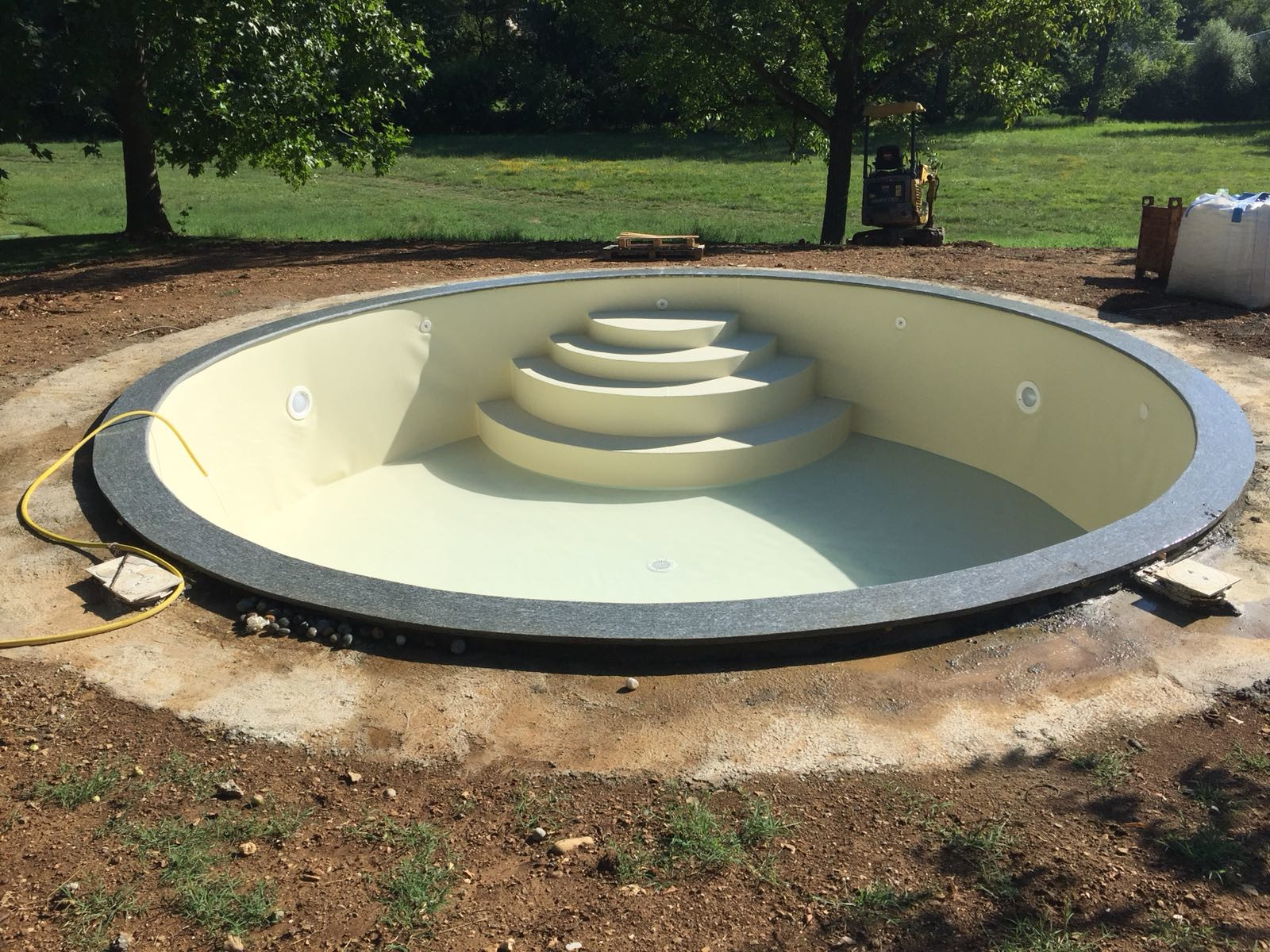 Realizzazione piscina interrata a skimmer sfioratori di forma rotonda realizzata da Acqua SPA® con blocchi in EPS isolante tipo Isoblock curvabili in forma libera, in fase di riempimento